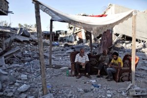 Palestinians sit amid the ruins of destroyed homes in the Shejaia neighbourhood of Gaza City