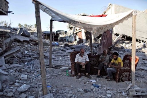Palestinians sit amid the ruins of destroyed homes in the Shejaia neighbourhood of Gaza City
